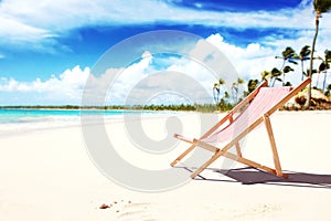 Relax on tropical beach in the sun on deck chairs