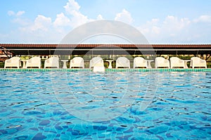 Relax white chairs By swimming poolside