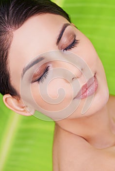 Relax, woman and beauty with makeup, leaf and cosmetics with green background. Skincare, wellness and dermatology with a