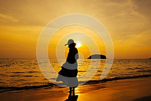 Relax Woman standing  on the beach  sea  Sunset silhouette