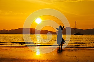 Relax Woman standing  on the beach  sea  Sunset silhouette