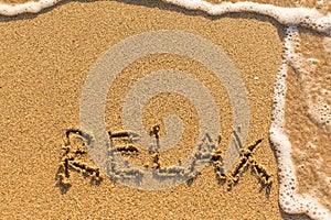Relax - word drawn on the sand beach