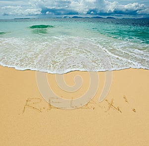 Relax written in a sandy tropical beach