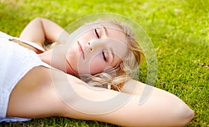 Relax, zen and a woman sleeping on grass outdoor in nature during summer for peace or quiet on a field. Spring, garden