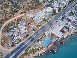 Relaxation area with swimming pool and beach umbrellas, asphalt motorway road and residential multi-storey buildings