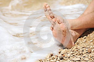 Relaxation on beach, detail of male feet