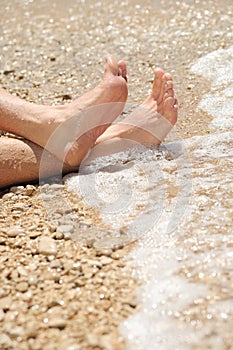 Relaxation on beach, detail of male feet