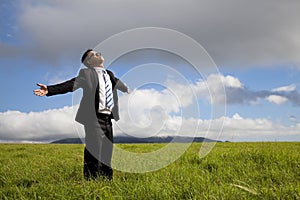 Relaxation businessman standing on the meadow