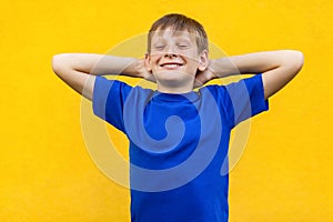 Relaxation concept. Happiness young boy, holding hand near head, closed eyes and relax.