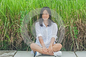 Relaxation Concept : Woman relaxing on concrete walkway at outdoor garden surrounded green natural.