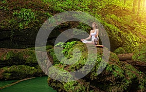 Relaxation in forest at the Waterfall. Ardha Padmasana pose