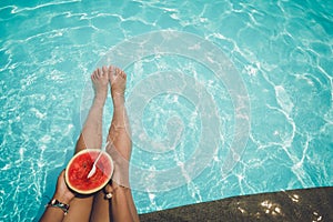 Relaxation and Leisure - Lifestyle in summer of Tanned girl holding watermelon Tropical fruit in the blue pool.