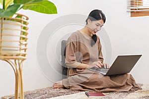 Relaxation lifestyle concept, Young Asian woman use laptop for entertainment in living room at home