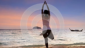 Relaxation lifestyle young woman practicing yoga on the beach with sunset sky scene background