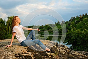 Relaxation, meditation mental health concept. National Relaxation Day. Red-haired woman meditates and relaxes in nature