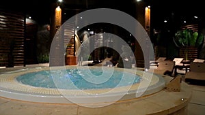 Relaxation pool in spa with waterfall. Empty luxury spa with jacuzzi and swimming pool. Jacuzzi in the sauna. Wellness