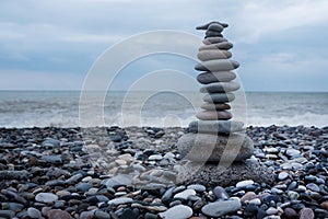 relaxation at sea. Stack of stones on beach nature background. Stone cairn on green blurry background