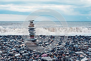 relaxation at sea. Stack of stones on beach, nature background. Stone cairn on sea blurry background, pebbles and stones