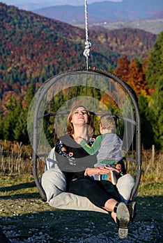 Relaxation. Women in swing. Mountain autumn landscape