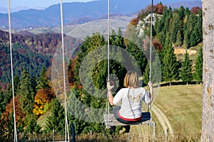 Relaxation. Women in swing. Mountain autumn landscape