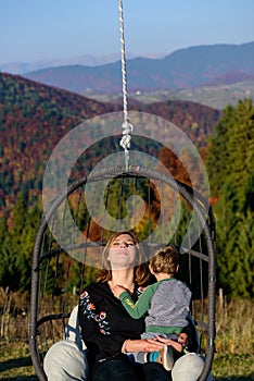 Relaxation. Women in swing. Mountain autumn landscape