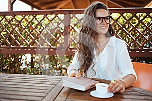 relaxed 40 years old housewife in shirt sitting at table