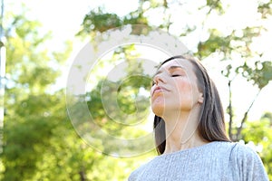 Relaxed adult woman breathing fresh air in a forest