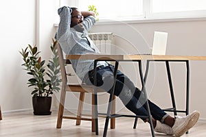 Relaxed african american businessman chilling in office room finished work photo