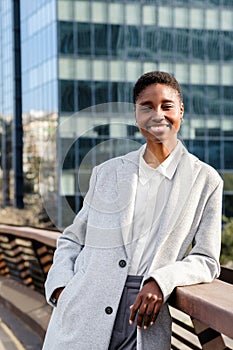 relaxed african business woman smiling and looking at camera at the financial district