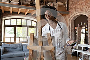 Relaxed Afro American professional artist working in home craft studio