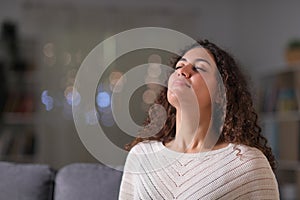 Relaxed woman breathing fresh air in the night at home photo