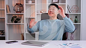 Relaxed Asian satisfied businessman happy man finish computer work close laptop.