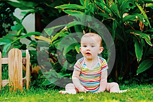 Relaxed baby enjoying the sensation of noticing the freshness of the grass on his bare feet