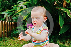 Relaxed baby enjoying the sensation of noticing the freshness of the grass on his bare feet
