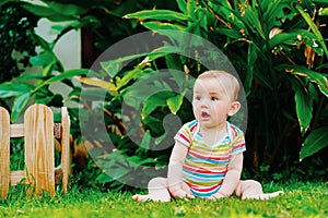 Relaxed baby enjoying the sensation of noticing the freshness of the grass on his bare feet