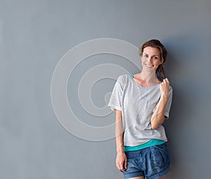 Relaxed beautiful woman smiling against gray background