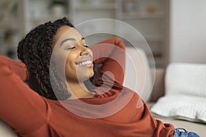 Relaxed Black Woman Enjoying Comfortable Moment on a Sofa at Home