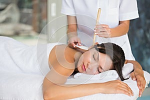 Relaxed brunette getting an ear candling treatment