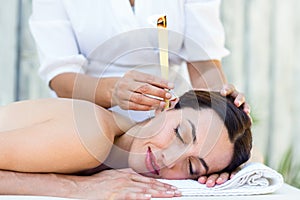 Relaxed brunette getting an ear candling treatment