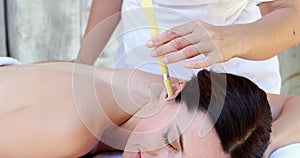 Relaxed brunette getting an ear candling treatment