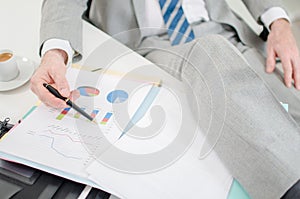 Relaxed businessman checking financial graphs