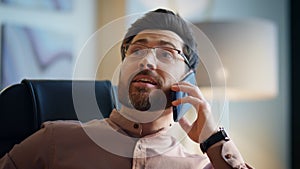 Relaxed businessman communicating smartphone sitting modern office close up.