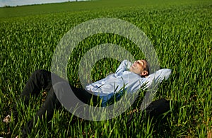 Relaxed Businessman Lying On Grass At Park