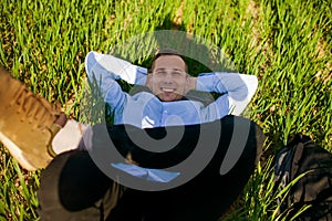 Relaxed Businessman Lying On Grass At Park