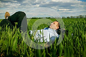 Relaxed Businessman Lying On Grass At Park