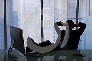 Relaxed Businessman Sitting At Computer Desk In Office