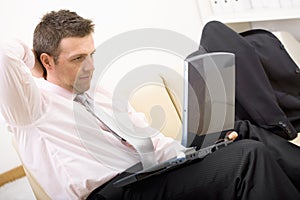 Relaxed businessman using laptop