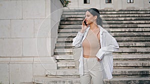 Relaxed businesswoman calling phone at staircase place. Lady talking telephone