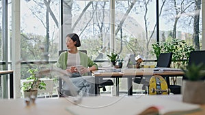 Relaxed businesswoman drinking coffee taking break office. Asian woman resting