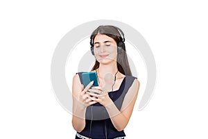 Relaxed casual woman listening calming music on headphones, holding her phone with closed eyes isolated over white background